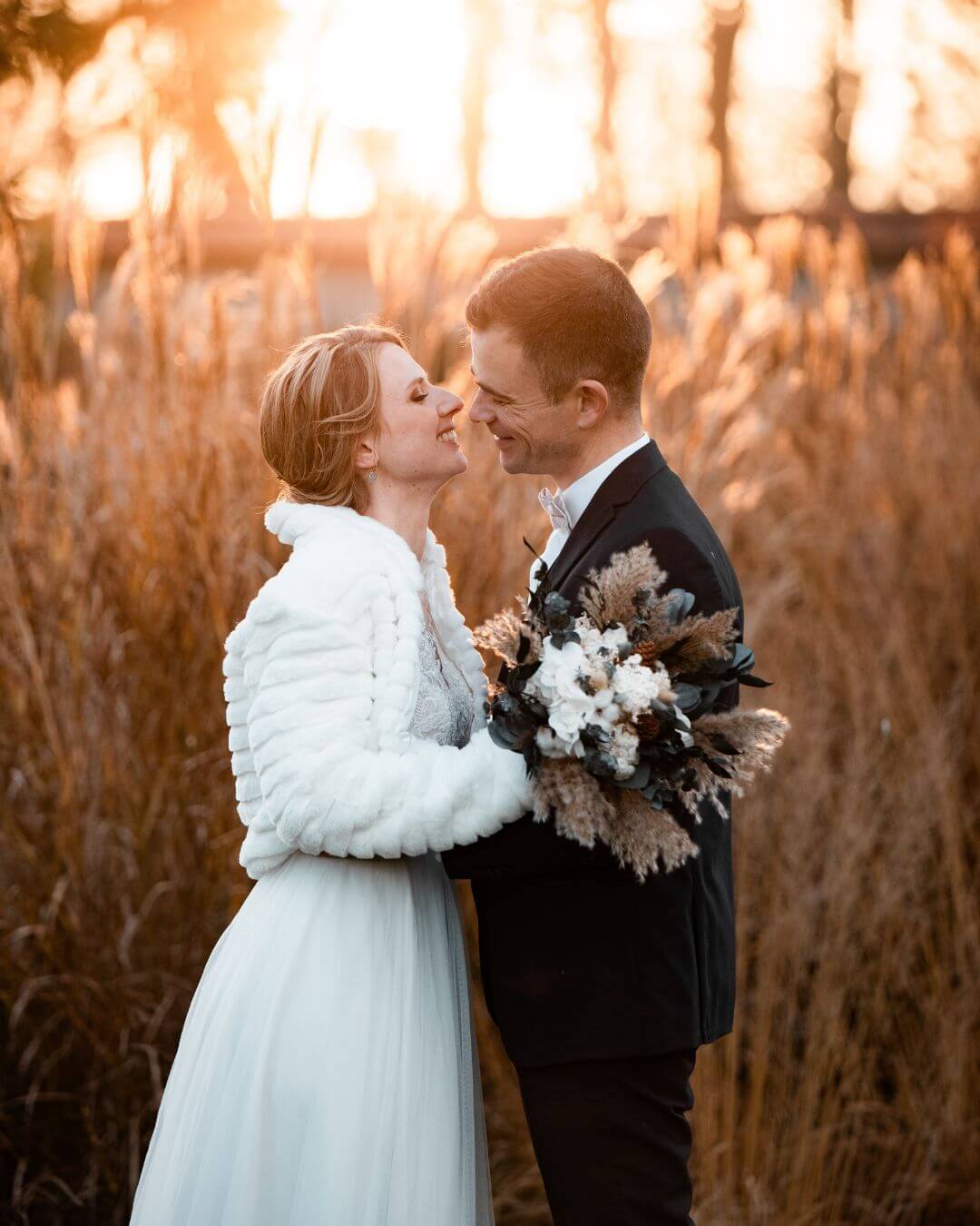 Couple de mariés l'hiver, en séance photo pendant la golden hour